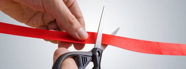 Man hands are cutting red ribbon with scissors. Opening event. Man hands are cutting red ribbon with scissors. Opening event.