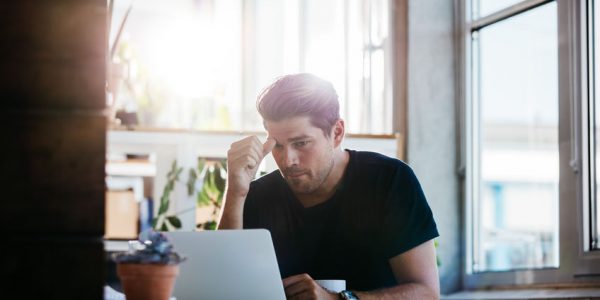 Business man thinking about a problem at his laptop Business man thinking about a problem at his laptop